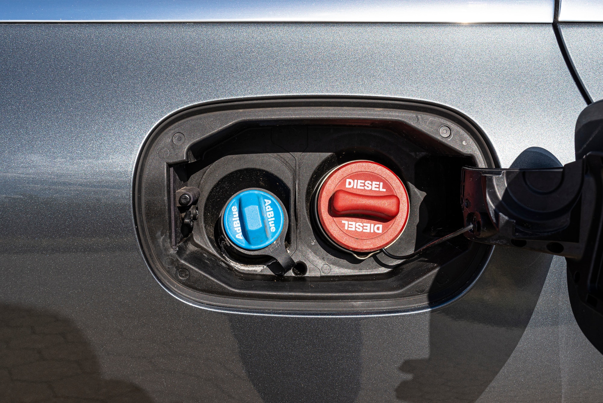 https://www.muchoneumatico.com/blog/wp-content/uploads/2023/02/fuel-filler-flap-open-with-red-diesel-cap-and-blue-adblue-the-fuel-filler-caps-are-closed-.jpg